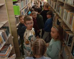 Grupa dzieci zwiedza wnętrze biblioteki