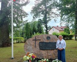 Zdjęcie pani Wójt przy pomniku poległych w czasie wojny.