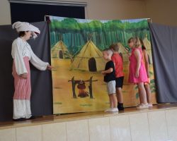 Dzieci na scenie z osobą przebraną za postać z bajek