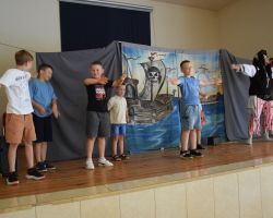 Dzieci na scenie z osobą przebraną za postać z bajek