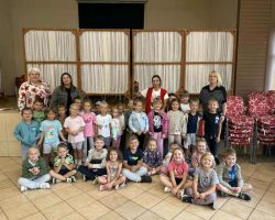 Zdjęcie grupowe przedszkolaków i bibliotekarki w bibliotece