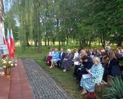 Uczniowie i nauczyciele na Narodowym Czytaniu w parku na ławeczkach