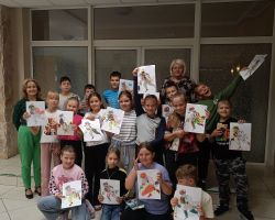 Zdjęcie grupowe uczniów i wykonanych przez nich prac plastycznych