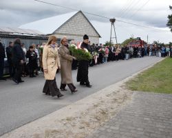 Złożenie kwiatów pod pomnikiem przez panią Wójt, proboszcza i panią Skarbnik