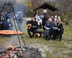 Ludzie przy wspólnym ognisku spiewają pieśni patriotyczne