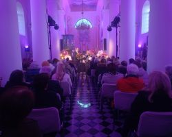 Na zdjęciu panowie składają życzenia wszystkim paniom na koncercie