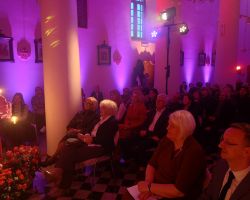 Na zdjęciu ludzie zebrani na koncercie Macieja Miecznikowskiego w zabytkowym kościele