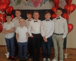 Na zdjęciu grupa chłopców ubranych elegancko pozuje do zdjęcia