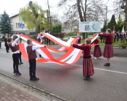 zdjęcie przedstawia dzieci tańczące z flagami