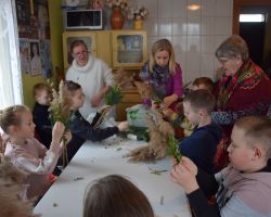 Zdjęcie przedstawia dzieci robiące palmy wielkanocne wraz z nauczycielami