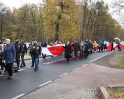 Zdjęcie przedstawia mieszkańców niosących flagę.