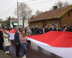 Zdjęcie przedstawia mieszkańców z flagą.