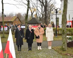 Zdjęcie przedstawia przedstawicieli szkół składających wiązanki.