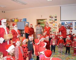 Zdjęcie przedstawia grupę przedszkolaków wraz z nauczycielami oraz Św. Mikołaje.