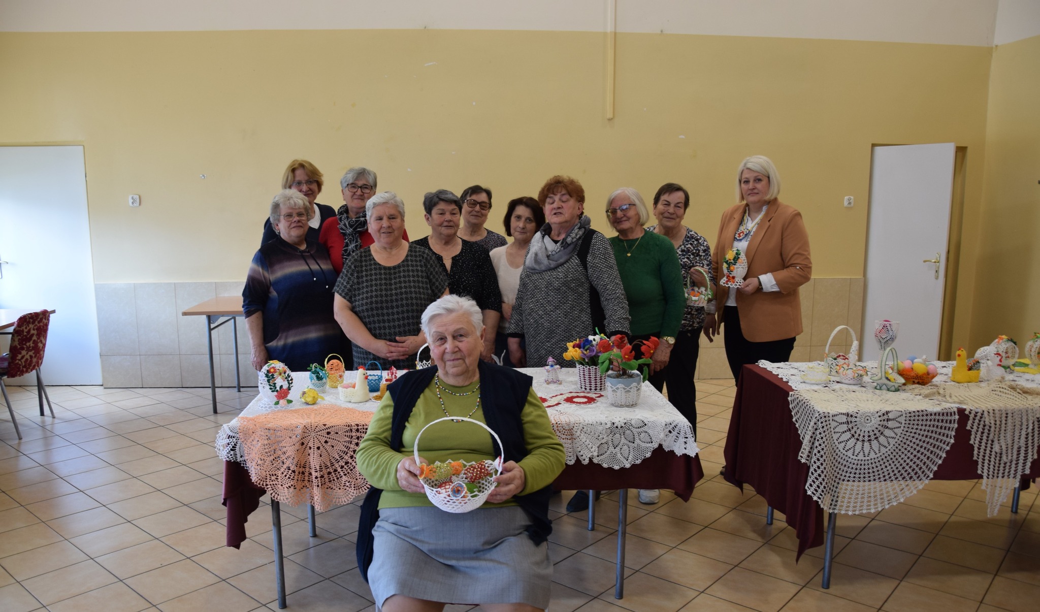 Zdjęcie grupowe seniorek podczas warsztatów szydełkowania.