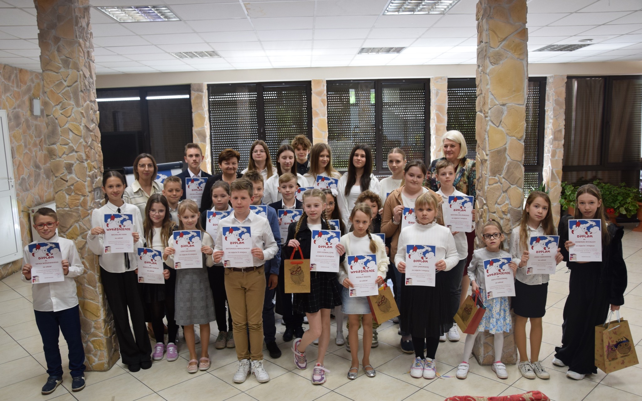 Zdjęcie grupowe uczniów z dyplomami i nagrodami za udział w konkursie.