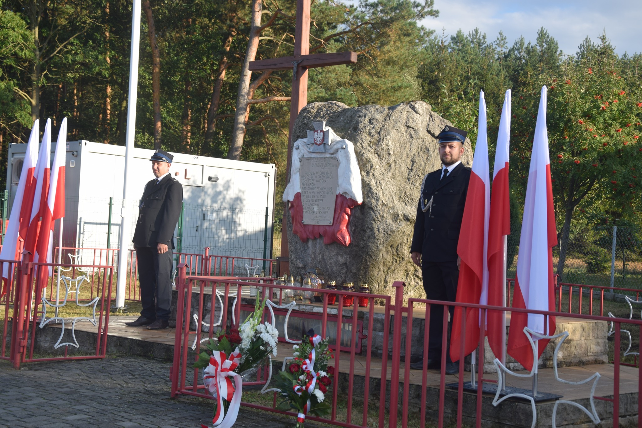 zdjęcie przedstawia strażaków pod pomnikiem w Jaźwinach