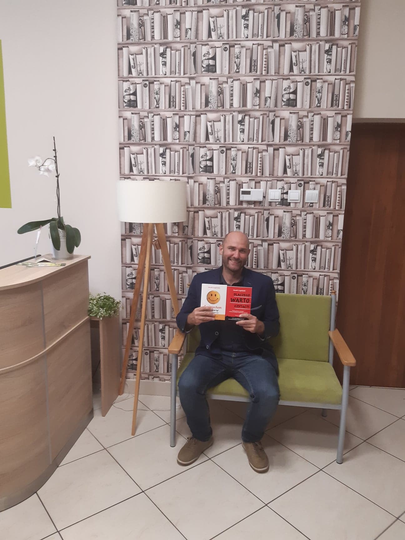 zdjęcie przedstawia autora z książkami