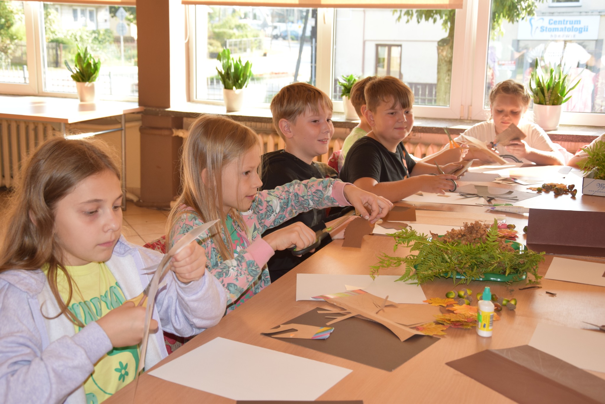 Zdjęcie przedstawia dzieci wykonujące prace plastyczne.