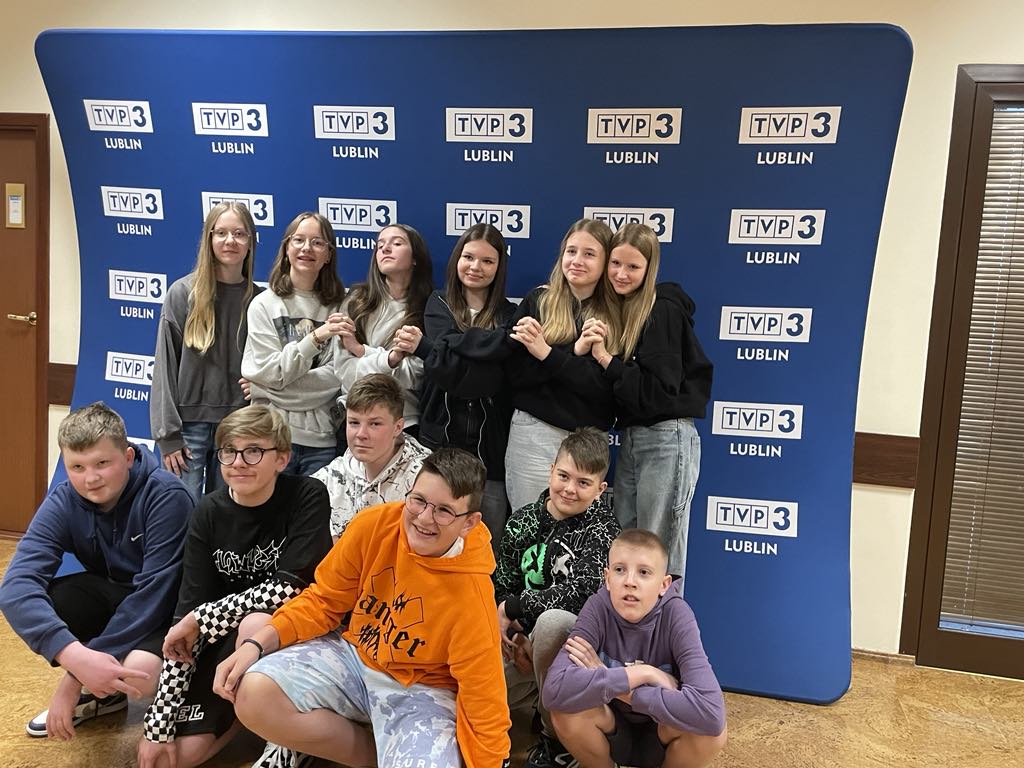 Zdjęcie grupowe młodzieży na tle ścianki TVP 3 Lublin.