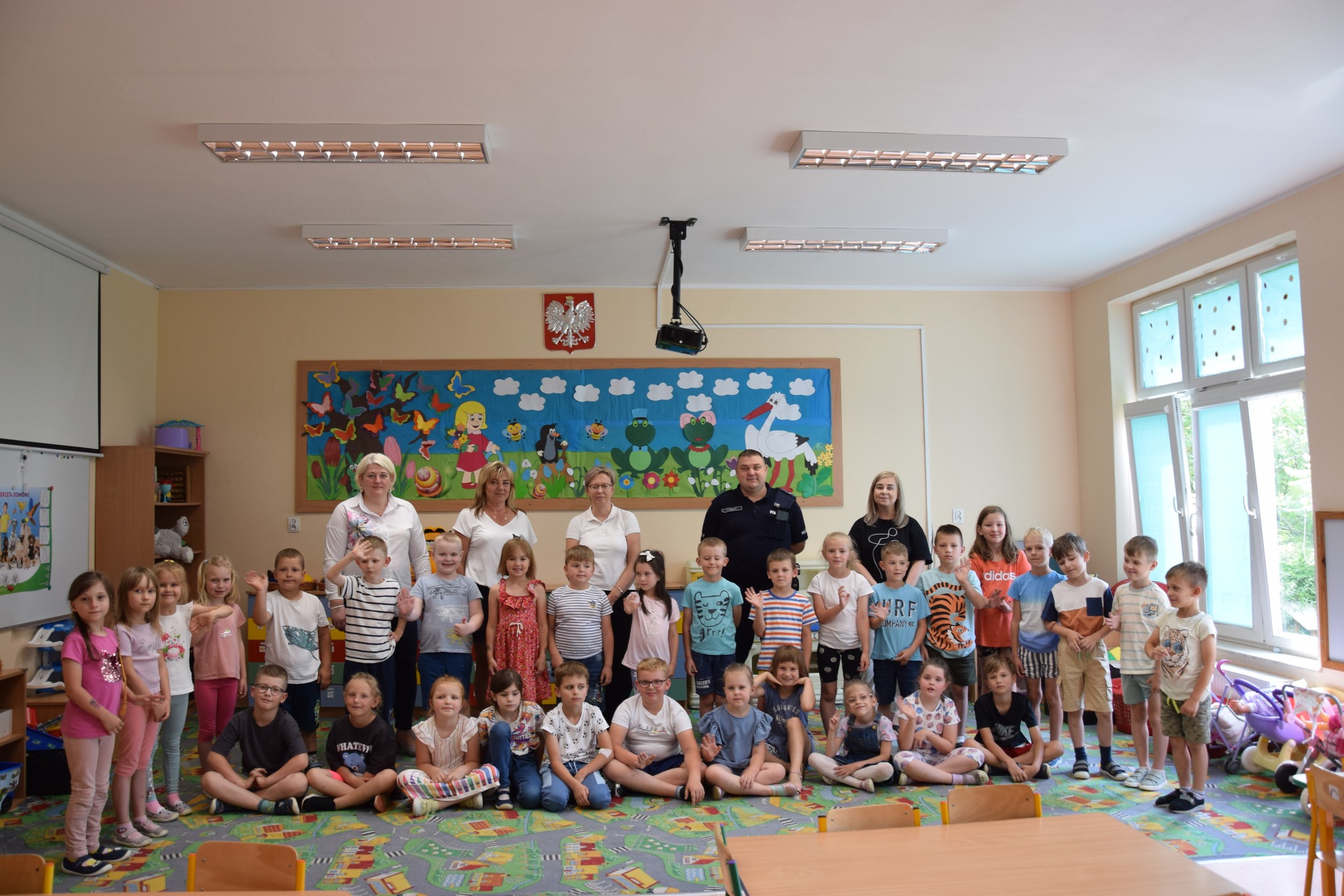 Zdjęcie grupowe dzieci z wychowawcami i dzielnicowym